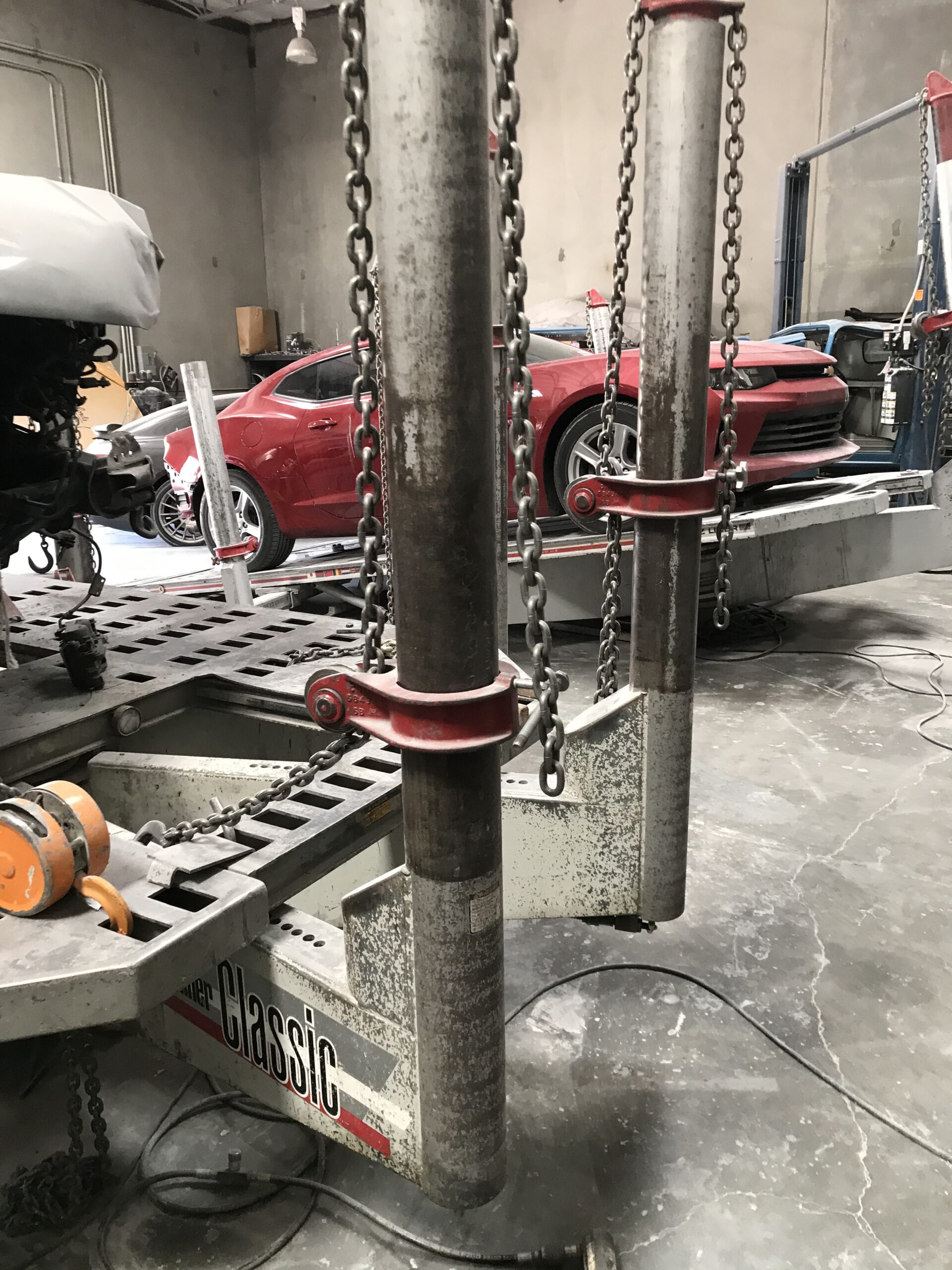 Elite Collision Auto Body shop interior with vehicles on lifts